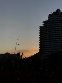 Low angle view of silhouette buildings against sky at sunset