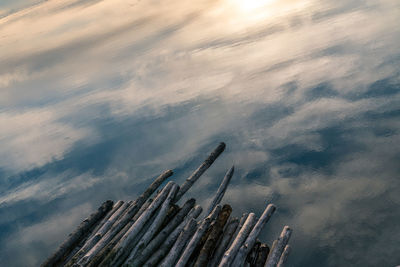 High angle view of wooden post against sky reflected in water