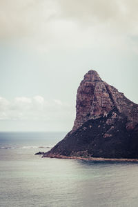 Rock formation in sea against sky