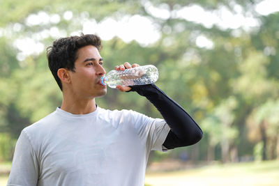 Young man drinking beer in water