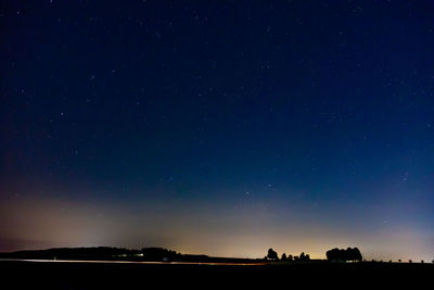 Scenic view of silhouette field against sky at night