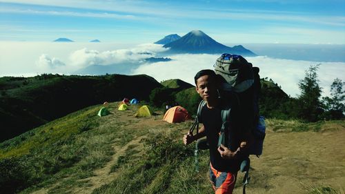 Friends standing on mountain against sky