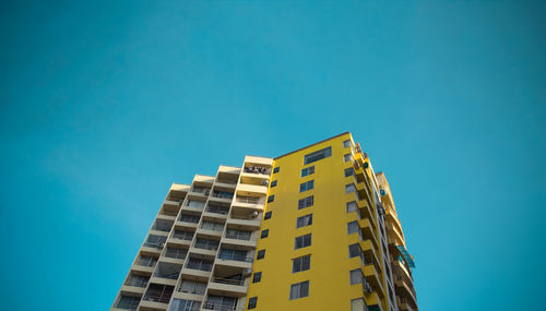 Low angle view of modern building against blue sky