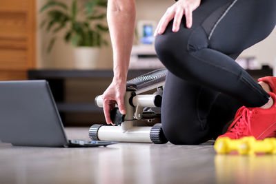 Low section of woman working out by laptop