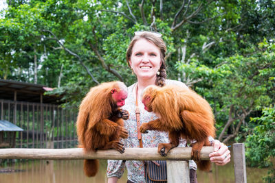 Portrait of woman with bald uakari monkeys