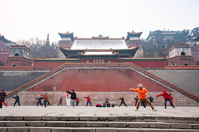 Group of people on building against clear sky