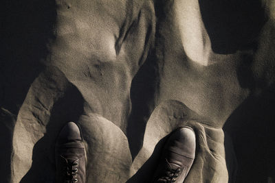 Midsection of shirtless man standing against black background