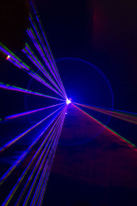 Close-up of illuminated light trails against blue sky