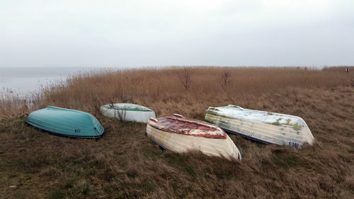 Rowboats moored at shore against sky