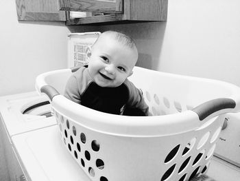 Smiling cute baby boy sitting in laundry basket