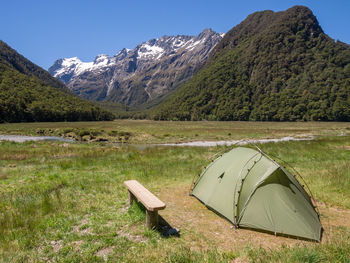 Tent on field by mountain against sky