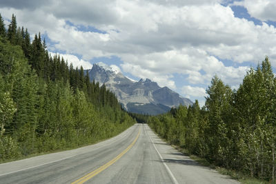 Road amidst trees against sky