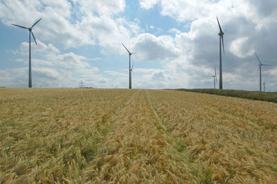 Traditional windmill on field against sky