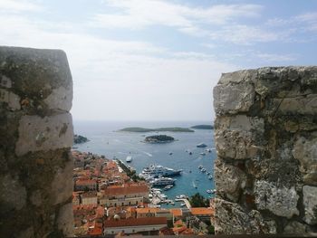 Buildings by sea against sky