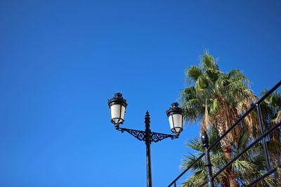 Low angle view of street light against blue sky