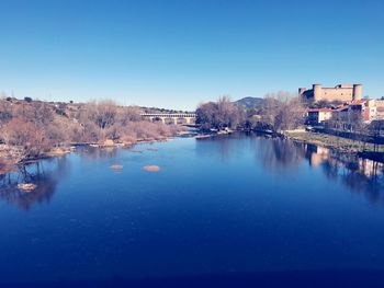 Scenic view of river against clear blue sky