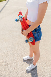 Teenage girl holding a skateboard