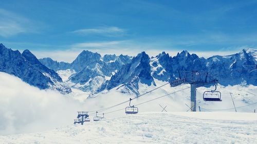 Ski lifts on snowcapped mont blanc against sky