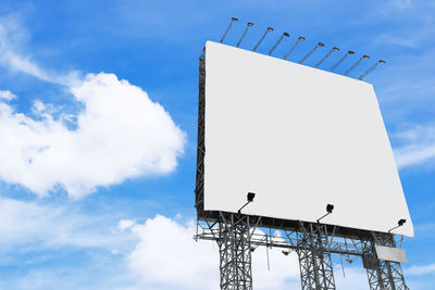 Low angle view of blank billboard against sky