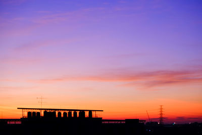 Silhouette buildings against sky during sunset
