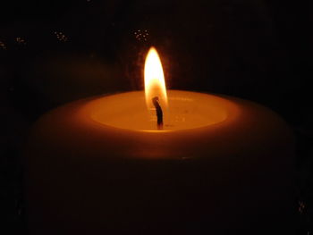 Close-up of lit candle in dark room