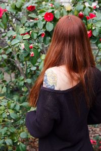 Rear view of woman standing by flowering plants