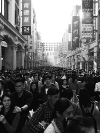 People on street in city against sky