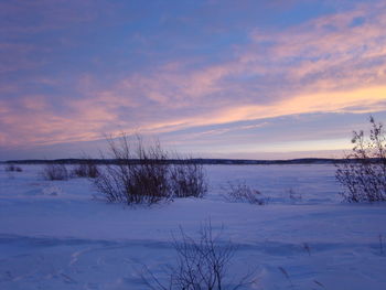 Scenic view of frozen lake against sky during sunset