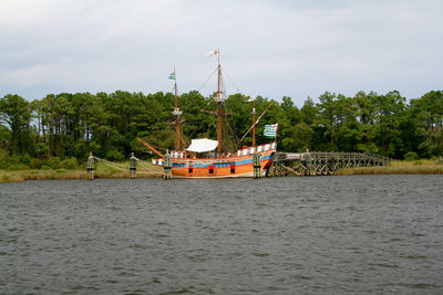 Boat sailing in river against sky