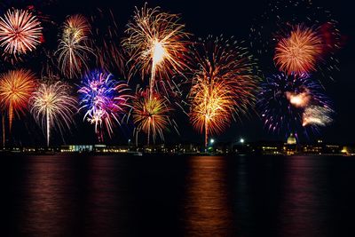 Firework display over river at night