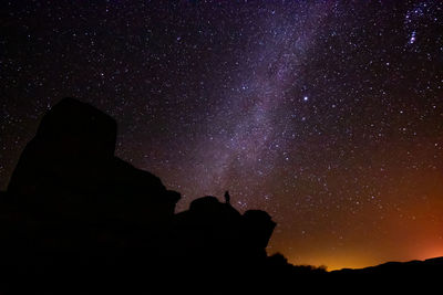 Low angle view of silhouette mountain against star field