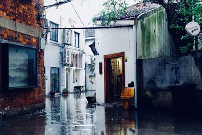 Buildings by wet street in city