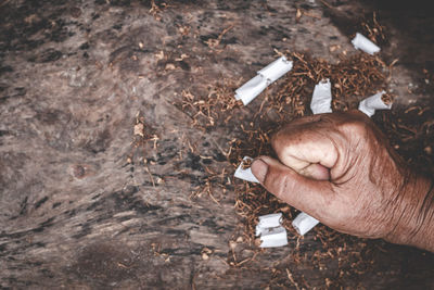 Cropped hand hitting cigarettes outdoors