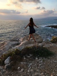 Woman at beach against sky