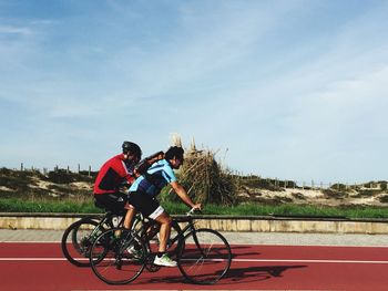 Man riding bicycle on road against sky