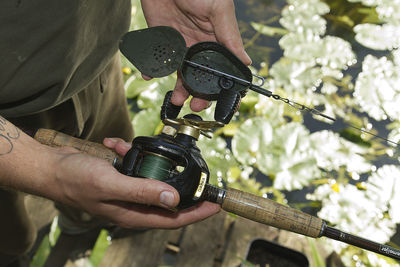 Midsection of man holding fishing rods