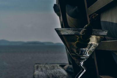 Close-up of metal by sea against sky