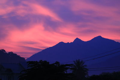 Scenic view of silhouette mountains against orange sky