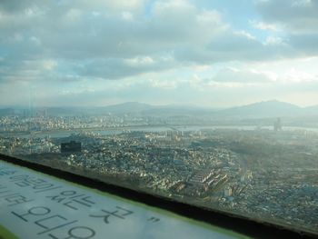 View of cityscape against cloudy sky