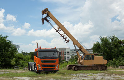 Crane and truck on field