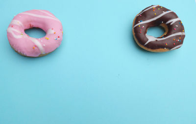 
chocolate and strawberry donuts on a blue background.