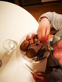 High angle view of hand holding ice cream on table