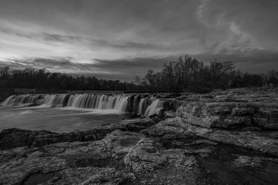 Scenic view of waterfall against sky