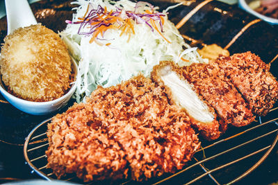 Close-up of tonkatsu and fry on barbecue grill