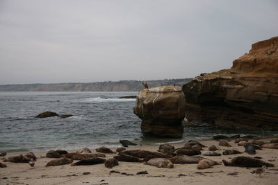 Rock formations by sea against sky