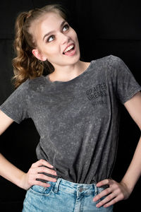 Portrait of a smiling young woman against black background