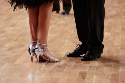 Low section of people walking on hardwood floor