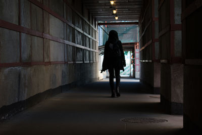 Rear view of woman walking in corridor