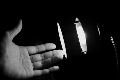 Close-up of human hand against black background