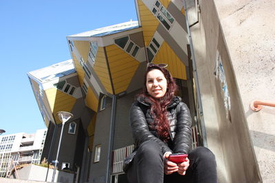 Portrait of smiling young woman sitting outdoors